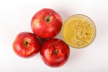 Red apples and a glass of fresh juice isolated on white background