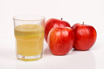 Red apples and a glass of fresh juice isolated on white background