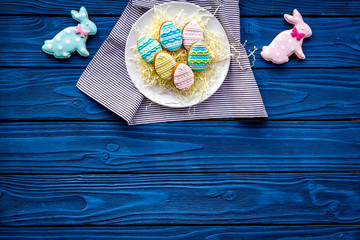Easter bunny and easter eggs cookies. Easter symbols and traditions. Blue wooden background top view copy space