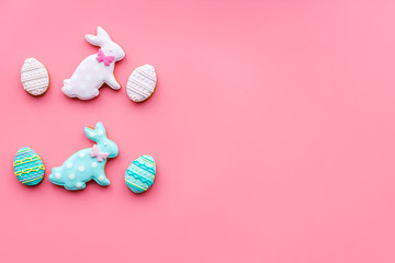 Easter bunny and easter eggs cookies. Easter symbols and traditions. Pink background top view copy space