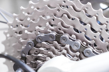 Obraz premium Mountain bike wheel and gear detail with a new clean chain and metal chain rings