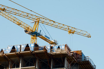 Fototapeta na wymiar Construction cranes against the blue sky. Construction. Apartments for sale. Housewarming