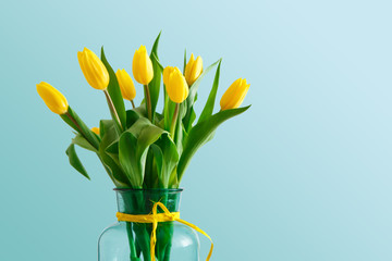 Yellow tulips bouquet on blue background
