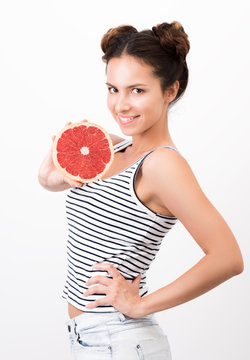 Joyful young woman demonstrates a grapefruit. Healthy, natural food