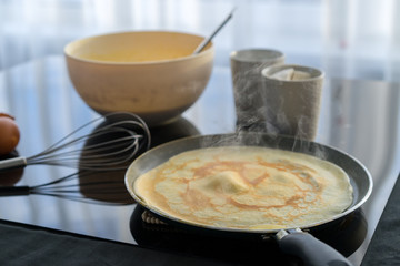 Ingredients for pancake on a black glossy background. Pancake day