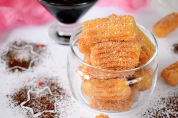 Spanish cookies Churros in a glass jar and chocolate sauce