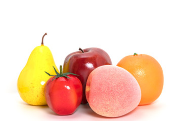 colorful plastic fruit over white background