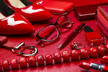 Red woman accessories, jewelry, cosmetic, shoes and other luxury objects on leather background, fashion industry, modern female concept, selective focus 