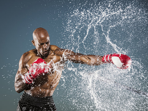Water splashing on black boxer punching - Powered by Adobe