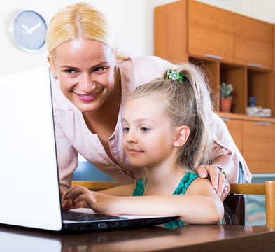 Happy mother teaching little daughter