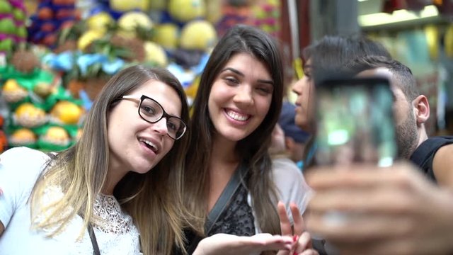 Friends taking a selfie with mobile in a Municipal Market, Sao Paulo, Brazil