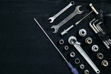 Set of hand bunch of tools in the garage on black wooden background