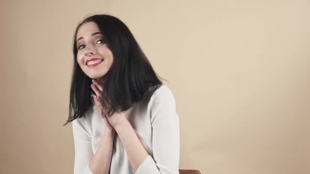  young beautiful cute brunette on a beige orange background showing gratitude, admiration, thx, thanks emotions
