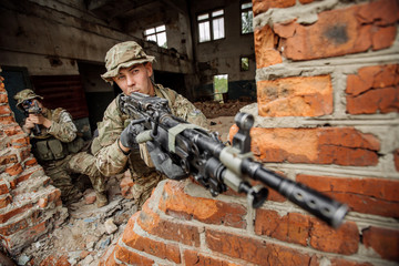 Fototapeta premium Soldiers on patrol in destroyed city. Military and rescue operation concept.