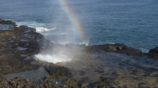Rainbow mist from Spouting Horn blowhole in the Koloa District of southern Kauai, Hawaii.