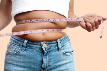 Overweight woman with tape measure around waist