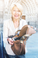 Mature woman is upset because her purse was been stole from bag