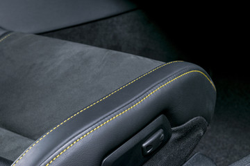 Modern Luxury car inside. Interior of prestige modern car. Comfortable leather seats. Black perforated leather with yellow stitching. Power seats