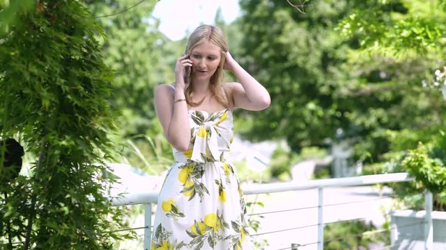 Young woman wearing sundress talking on smart phone