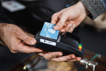 Customer is paying with contactless credit card in shop.