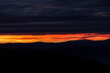 Fototapeta premium Glowing sky and dramatically colored clouds during sunset, view from Kopitoto Hill, Vitosha Mountain, Sofia, Bulgaria