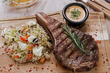 grilled beef steak on bone striploin with rice and vegetables