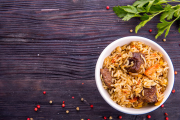 Pilaf with pieces of meat, rice and carrot with greens