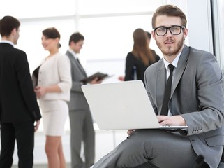 Manager with documents on the background of colleagues