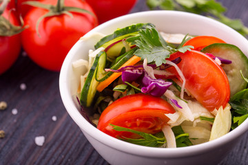 Cabbage salad, tomatoes, cucumbers and greens, the seasoned olive oil