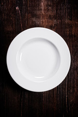 weisser Teller auf dunklen holz