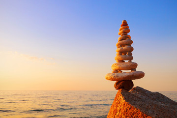Stones balance on a background of sea sunset. Concept of harmony and balance