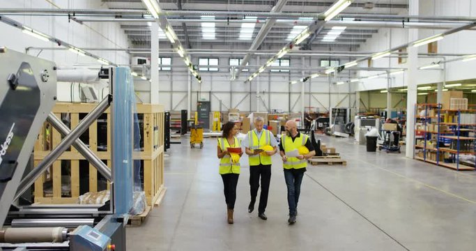 4k, Team of warehouse workers walking inside a printing, packaging and distribution factory. Slow motion.
