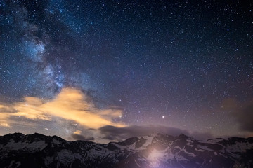 Milky Way starry sky rocky mountains profile silhouette captured from high altitude on the Alps.