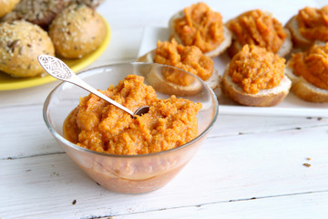 Homemade vegetable (pumpkin, paprika) sauce. Sandwiches with pumpkin dip on white wooden table. 