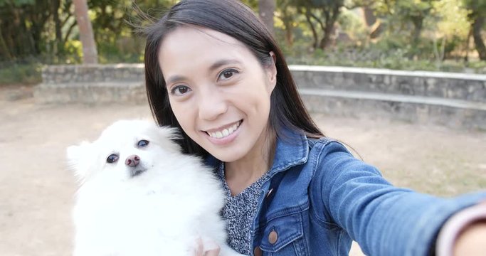 Woman taking selife with her dog at outdoor park
