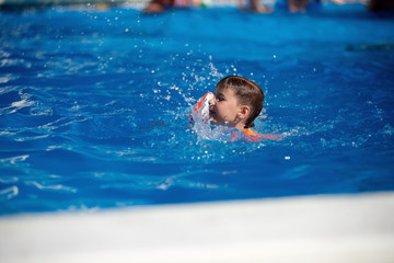 Caucasian boy swimming in the pool.