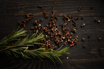 Spices and herbs on the black wood background.