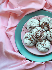 Chocolate cookies on plate onpink tablecloth, top view. Food, junk-food, culinary, baking and eating concept.