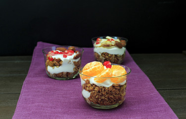 Granola with yogurt and fruits in small glass. Delicious healthy American food for breakfast. Traditional US snack. Top view.