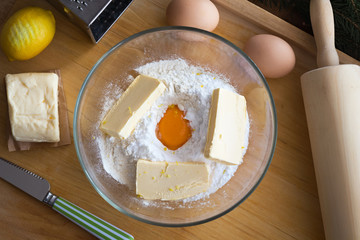 Ingredients for preparing Christmas cookies in a glass bowl