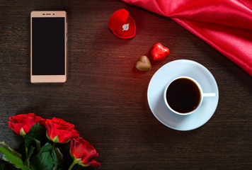 Happy Valentines Day romantic background with wedding ring, rose flowers, smartphone, cup of coffee and chocolate candy
