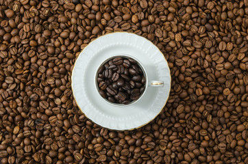 cup of black coffee beans and roasted coffee beans. View fromd above.