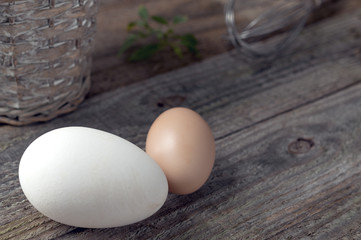 Goose and hen eggs on wooden table