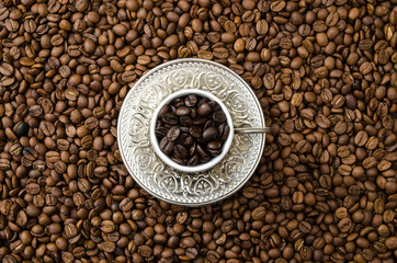 cup of black coffee beans and roasted coffee beans. View fromd above.