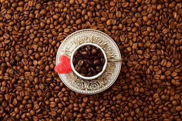 cup of black coffee beans and roasted coffee beans with jelly heart. View fromd above.