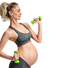 Pregnant woman doing sport stretching exercises green weights. Pregnancy motherhood expectation healthy life and weight control concept