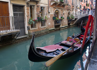 Fototapeta na wymiar Venice, Italy-April 6, 2011-The antique gondola moored on a Venetian canal