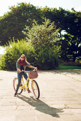 Young beautiful woman riding a bicycle in a park. Active people. Outdoors