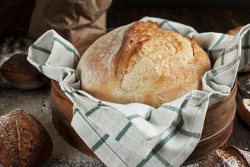 freshly baked bread on a wooden table on a dark background
