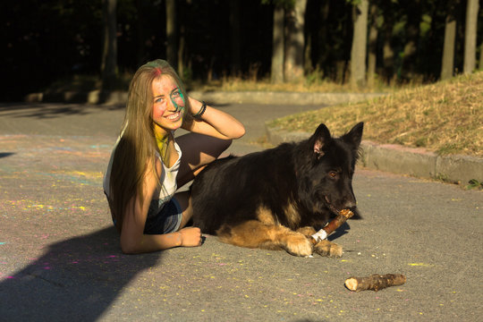 Positive blonde model posing with big sheepdog at Holi festival